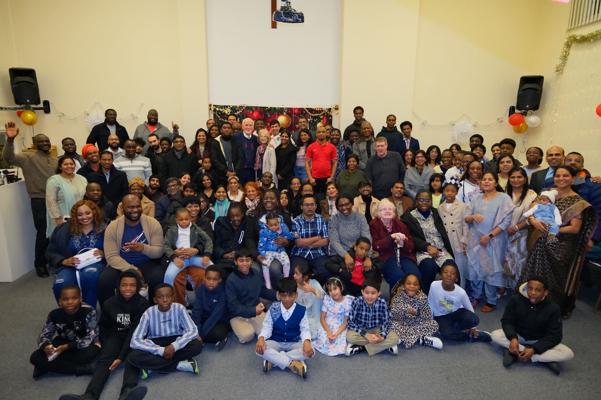 The King's Christian Centre church family — all ages and many nations — gathered together for a group photo at Christmas 2025