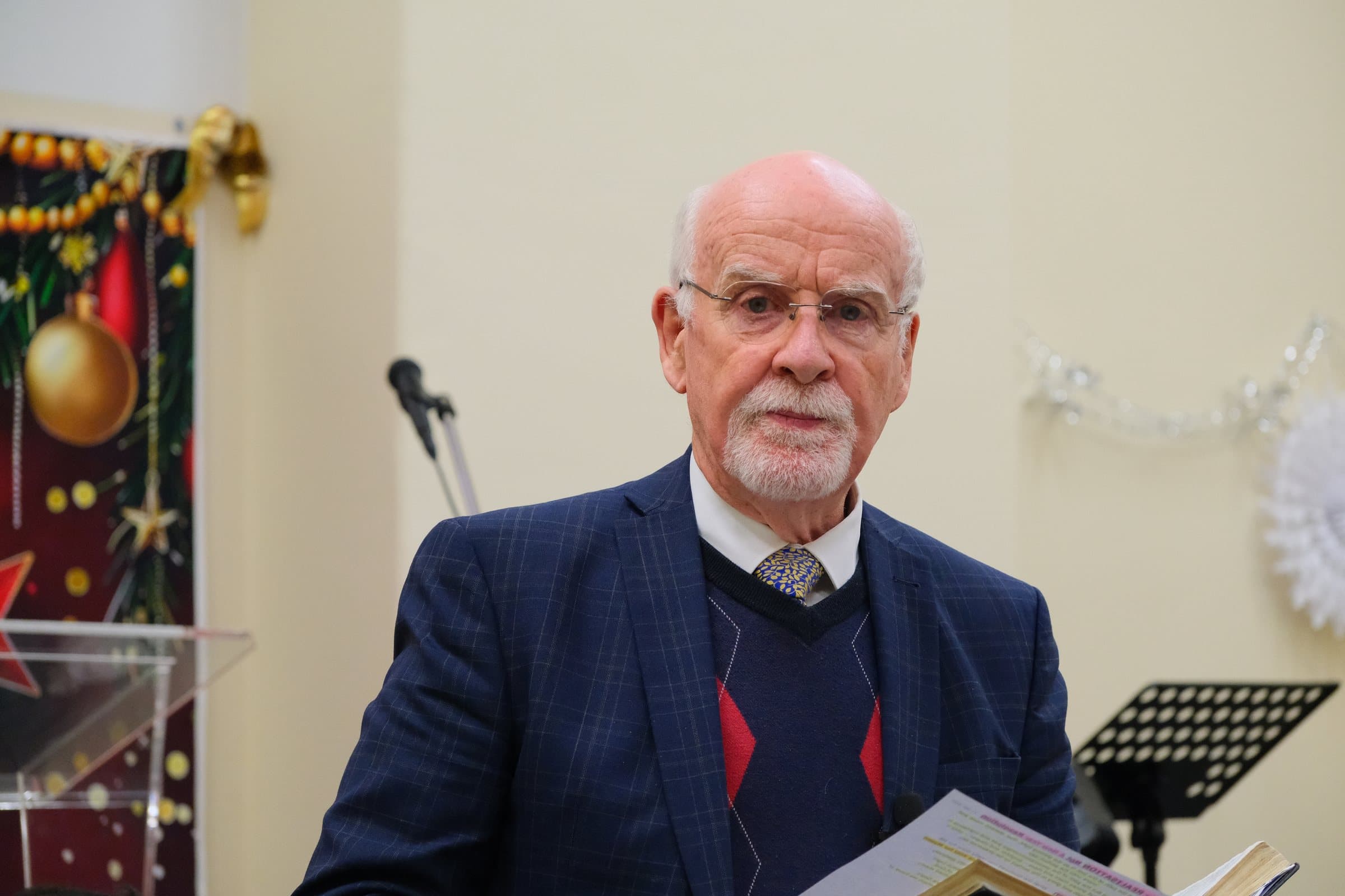 Pastor Malcolm Macqueen holding his Bible as he speaks at King's Christian Centre